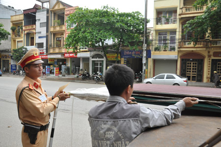 Cán bộ Đội Cảnh sát giao thông số 3 kiểm tra kích thước hàng hóa chuyên chở trên các phương tiện giao thông