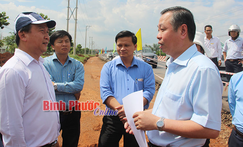 Phó chủ tịch UBND tỉnh Huỳnh Anh Minh (bên phải) cùng đoàn đi kiểm tra thực tế và nghe đại diện Công ty Điện lực Bình Phước báo cáo việc di dời đường điện phục vụ dự án