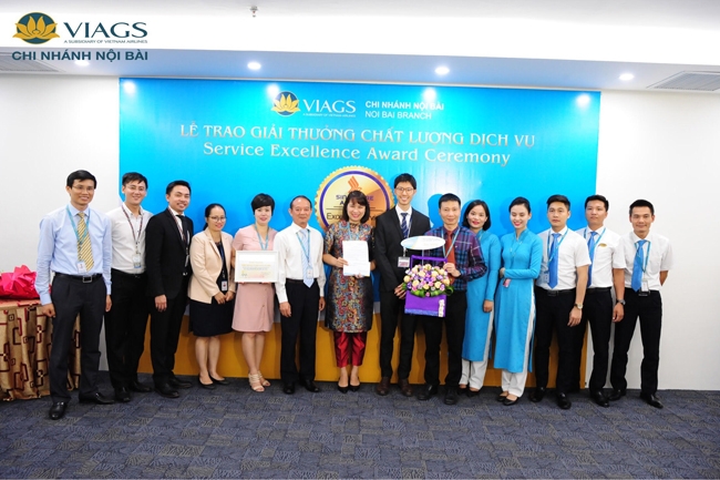 Ðại diện lãnh đạo, cán bộ, nhân viên Công ty VIAGS (đơn vị thành viên của Vietnam Airlines) nhận giải thưởng về chất lượng dịch vụ  Trong một diễn biến khác, Singapore Airlines cũng đã trao giải thưởng ghi nhận chất lượng dịch vụ của hai đơn vị thành viên VNA phục vụ cho các chuyến bay đi/đến sân bay quốc tế Nội Bài của hãng này.  Theo đó, hai đơn vị thành viên của VNA gồm Công ty cổ phần Dịch vụ hàng hóa Nội Bài (NCTS) đã xếp hạng thứ hai về chất lượng phục vụ hàng hóa và Công ty Dịch vụ mặt đất sân bay Việt Nam (VIAGS) đạt giải thưởng "Ðầu sân bay có chất lượng dịch vụ tốt nhất" đối với công tác làm thủ tục hành khách, hành lý tại sân bay Nội Bài.  Giải thưởng này đã được ông Kaijie Yeo, Giám đốc điều hành hãng Singapore Airlines tại Việt Nam khu vực miền bắc và ông Dennis Chia Guo Wei, Trưởng đại diện hãng tại sân bay Nội Bài trao tặng. Các giải thưởng dựa trên đánh giá khách quan của hành khách trên các chuyến bay trong toàn mạng bay của Singapore Airlines trên khắp thế giới do hãng thực hiện từ tháng 4/2016 đến tháng 3/2017. Hiện tại, NCTS và VIAGS đang phục vụ các chuyến bay của Singapore Airlines đi/đến Hà Nội với tần suất bảy chuyến/tuần.  NCTS là công ty cung cấp dịch vụ phục vụ hàng hóa lớn nhất cho 23 hãng hàng không đang khai thác tại sân bay Nội Bài, đặt mục tiêu trở thành nhà cung cấp dịch vụ phục vụ hàng hóa hàng không hàng đầu khu vực Ðông  Nam Á. Ngoài giải thưởng của Singapore Airlines, NCTS còn nhận được kết quả đánh giá chất lượng phục vụ hàng hóa rất tốt của Cục Hàng không Qatar và các hãng hàng không đối tác lớn khác. Trong lĩnh vực phục vụ mặt đất, VIAGS là mô hình kinh doanh đầu tiên ở Việt Nam chuyên cung cấp các dịch vụ mặt đất sân bay đồng bộ, đạt chuẩn quốc tế tại ba sân bay lớn là Nội Bài, Tân Sơn Nhất và Ðà Nẵng.  Ngoài việc tuân thủ Quy chế an ninh hàng không của Bộ Giao thông vận tải (GTVT) và đạt chứng nhận tiêu chuẩn ISO 9001:2015, VIAGS vừa hoàn thành đánh giá giai đoạn 1 cho việc chứng nhận tiêu chuẩn quốc tế ISAGO ED5 (IATA Safety Audit for Ground Operations - hệ thống tiêu chuẩn bảo đảm an toàn cao nhất trong quy trình phục vụ mặt đất của IATA).  Ông Christian Abrecht, đánh giá viên trưởng người Ðức có hàng chục năm kinh nghiệm đã nhận định: "VIAGS là công ty phục vụ mặt đất hàng đầu trong nước và có tiềm năng lớn cung cấp dịch vụ mặt đất trên thị trường quốc tế". Với chất lượng dịch vụ nâng cấp tổng thể trên toàn mạng từ mặt đất đến trên không, VNA hiện là hãng hàng không duy nhất tại Việt Nam cung cấp dịch vụ truyền thống, đầy đủ với chất lượng quốc tế nằm trong tốp các hãng hàng không 4 sao của thế giới.  Theo cập nhật xếp hạng mới nhất của tổ chức đánh giá các hãng hàng không độc lập SkyTrax, VNA đứng thứ 14 trong nhóm 20 hãng hàng không có hạng Phổ thông đặc biệt tốt nhất thế giới năm 2017 (World's Best Premium Economy Class 2017). Giải thưởng hàng không thế giới năm 2017 của SkyTrax được trao căn cứ vào kết quả khảo sát hành khách trong giai đoạn từ tháng 8/2016 đến tháng 5/2017. Ðây là tiền đề để hãng sớm hiện thực hóa mục tiêu trở thành một trong những hãng hàng không được ưa chuộng nhất khu vực châu Á - Thái Bình Dương vào năm 2020.  Hạng Phổ thông đặc biệt là hạng ghế nằm giữa hạng Thương gia và hạng Phổ thông.   Hạng Phổ thông đặc biệt của VNA hiện được mở bán trên các đường bay quốc tế đi Pháp, Anh, Ðức, Australia và Nhật Bản (Narita, Haneđa). Hành khách mua vé hạng Phổ thông đặc biệt được ưu tiên làm thủ tục tại quầy check-in riêng và lối đi lên tàu bay ưu tiên; tiêu chuẩn hành lý miễn cước 40 kg tương đương với hạng Thương gia và hành lý được gắn thẻ ưu tiên, nhanh chóng nhận được hành lý ký gửi khi hạ cánh. Ghế ngồi khoang Phổ thông đặc biệt có không gian rộng hơn và thoải mái hơn.  Đây là năm thứ 2 liên tiếp VNA nằm trong top 50 hãng hàng không hàng đầu thế giới theo đánh giá của SkyTrax. Ðây là sự ghi nhận lớn của hành khách trên toàn cầu cũng như cộng đồng hàng không quốc tế đối với những cố gắng, nỗ lực không ngừng cải tiến vượt bậc về chất lượng dịch vụ của VNA trong năm 2016.  Năm 2017, VNA phấn đấu đạt tổng sản lượng vận chuyển hành khách hơn 22,5 triệu lượt; doanh thu hợp nhất 87.900 tỷ đồng, trong đó công ty mẹ đạt 66.872 tỷ đồng, lợi nhuận trước thuế hợp nhất toàn Tổng công ty đạt 1.638 tỷ đồng. Thời gian tới, VNA sẽ phát hành thêm hơn 191 triệu cổ phiếu, dự kiến thu hơn 1.911 tỷ đồng, dùng để thực hiện các dự án mua máy bay Boeing 787-9, Airbus A350-900 XWB và thanh toán các dịch vụ phục vụ hoạt động sản xuất, kinh doanh. Năm 2017, Vietnam Airlines có hai dự án đầu tư máy bay trị giá hơn 2.111 tỷ đồng gồm 10 chiếc A350-900XWB và tám chiếc Boeing 787-9, chiếm tỷ trọng 72% kinh phí đầu tư năm 2017.