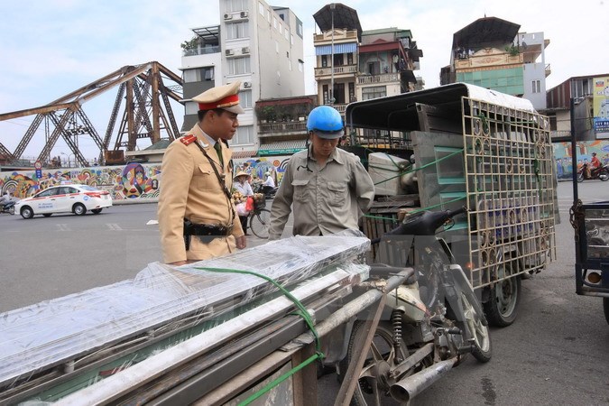 Cảnh sát giao thông Đội 1, Công an Hà Nội kiểm tra, xử lý xe chở hàng cồng kềnh. (Ảnh: TTXVN)