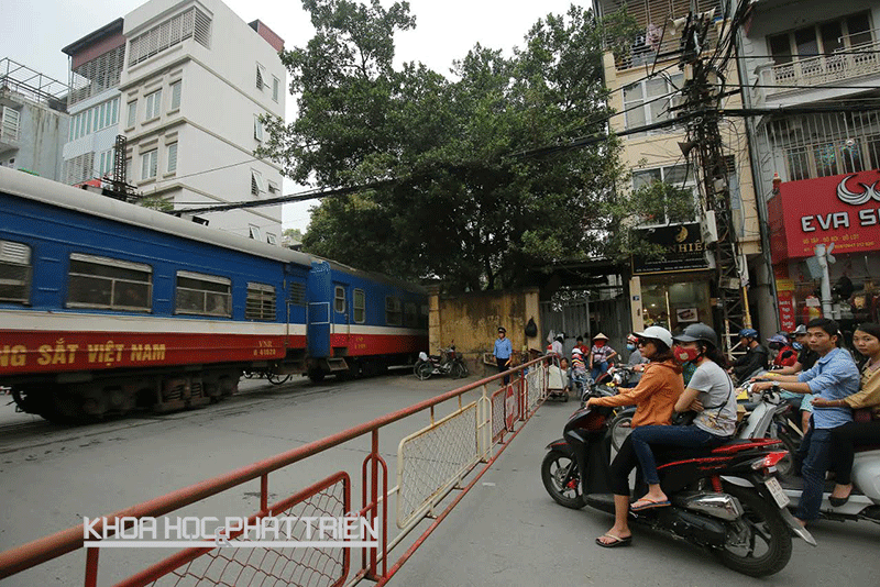 Người dân đứng chờ tàu chạy qua trên đường Khâm Thiên (Đống Đa, Hà Nội).