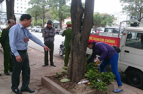 Tổ công tác thuộc phường Dịch Vọng Hậu, Cầu Giấy nhắc nhở, yêu cầu   các hộ dân kinh doanh buôn bán vỉa hè thu dọn rác thải. Ảnh: Sơn Dương