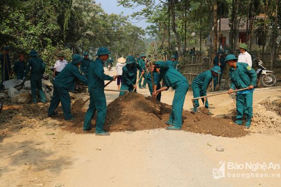 Hơn 100 dân quân tự vệ được huy động giúp người dân duy tu bảo dưỡng tuyến đường. Ảnh: Huyền Trang